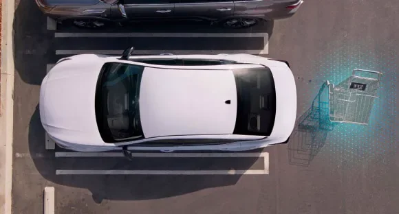 Top view of a white 2027 Nissan Altima in a parking lot with rear sensors detecting a shopping cart behind it at Reed Nissan Orlando in Orlando FL