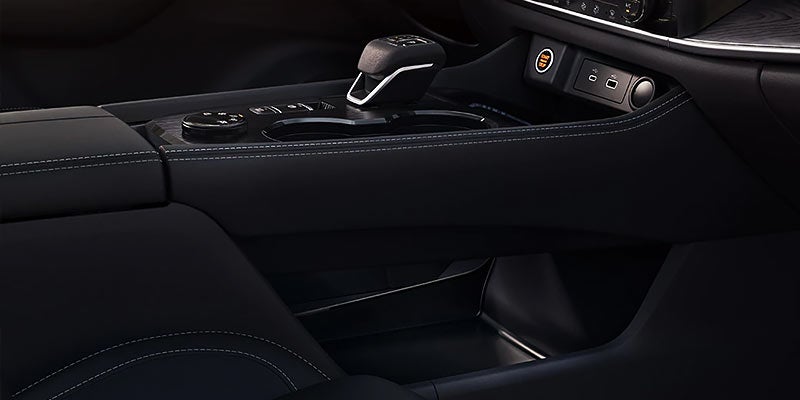 Close-up of a modern car center console with gear shifter and control buttons.