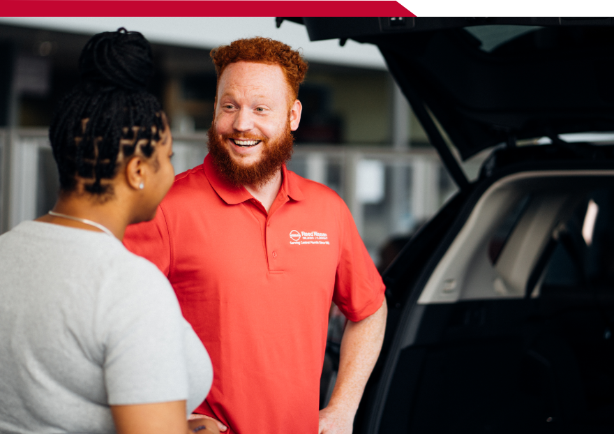 Two people discussing a Nissan vehicle